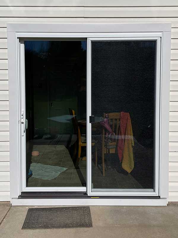 Exterior view of a white Marvin Replacement two-panel sliding patio door.