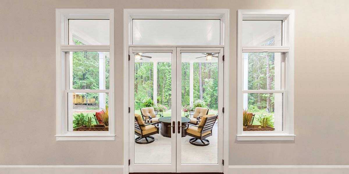 inswing patio door framed by double hung windows