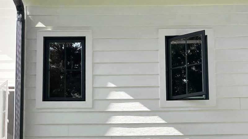 Exterior view of installed Marvin Replacement Casement windows with divided lites and ebony finish.