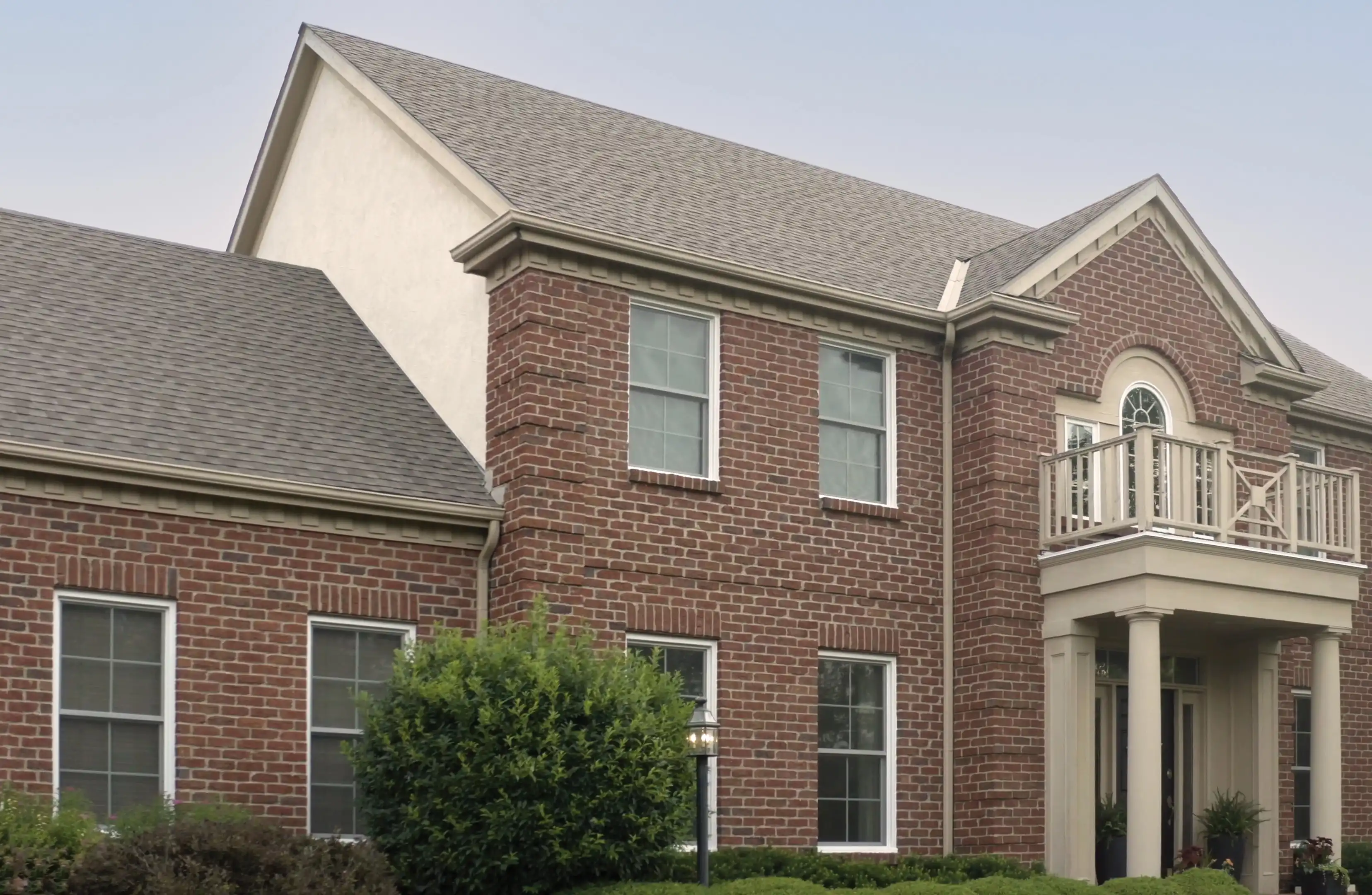 Exterior view of a brick home with Marvin Replacement Double Hung Windows.