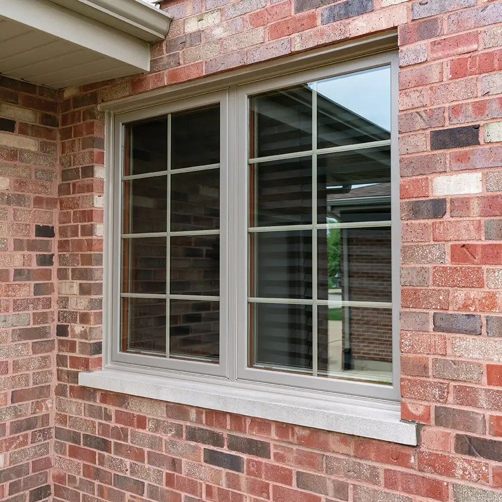 Exterior view of brown casement windows on a brick home.
