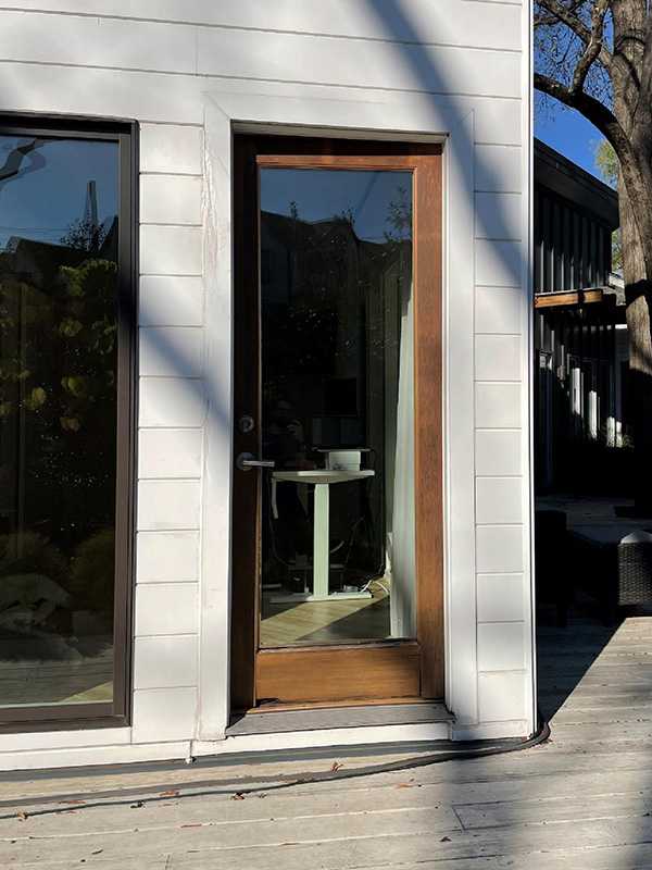 Exterior view of an old wooden inswing French patio door.