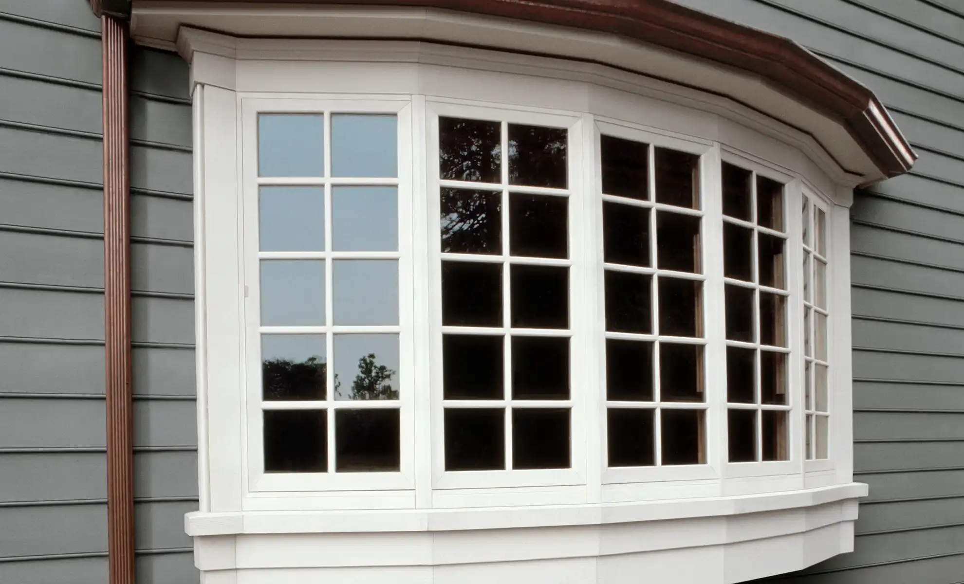 White Marvin Replacement Bow Window with five panels on a house with grey siding.