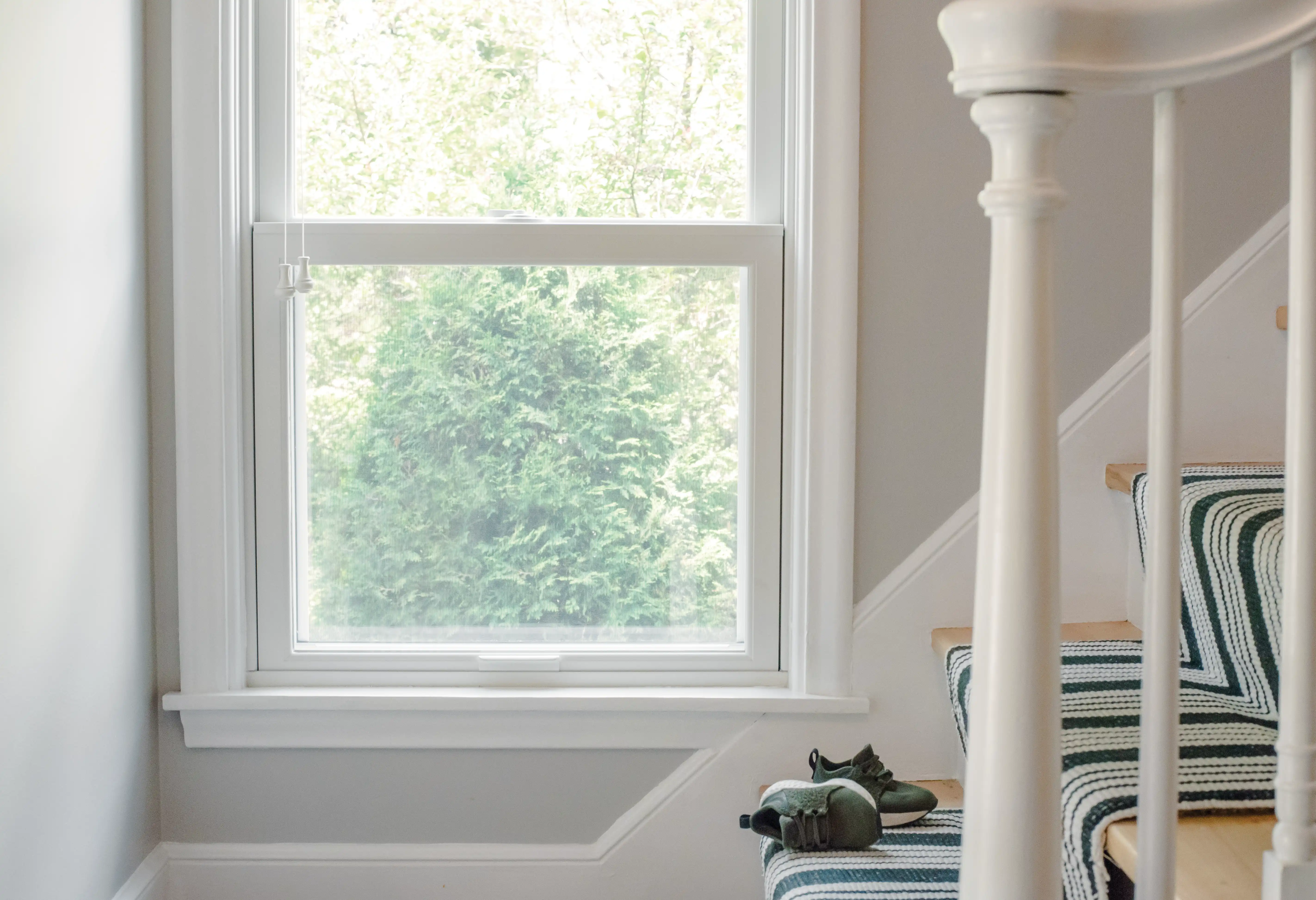 A white Marvin Replacement Double Hung window along a staircase.