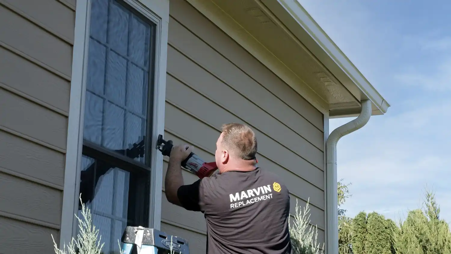Man uses a reciprocating saw to cut a window frame