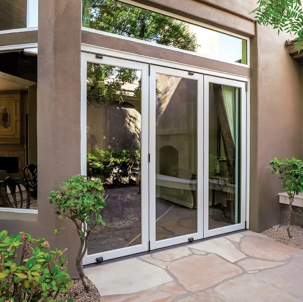Exterior view of a three-panel white Marvin Replacement bi-fold patio door.