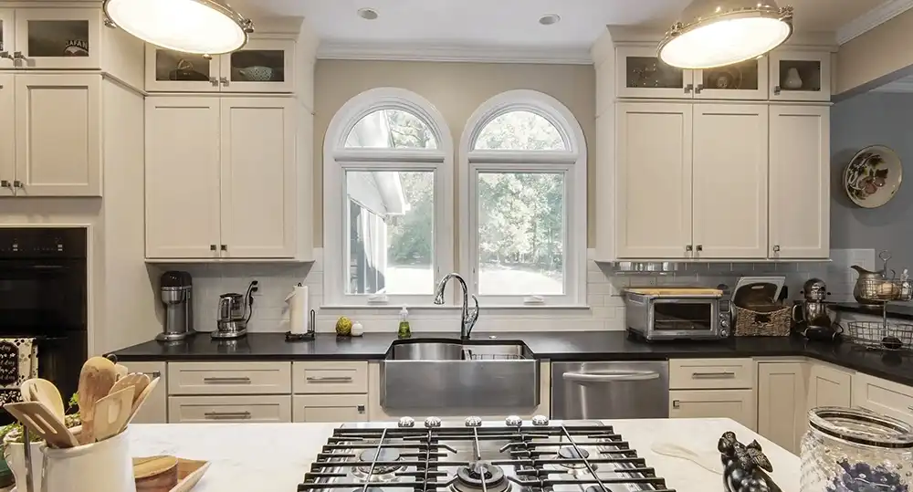Interior view of a kitchen with Marvin Replacement Round Top windows above a kitchen sink.