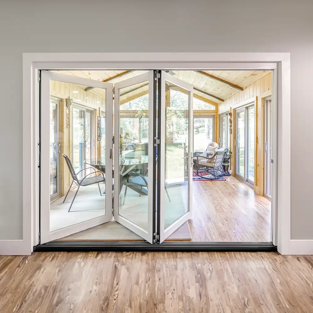 Interior view of an opened Marvin Replacement four-panel bi-fold door leading to a sun room.