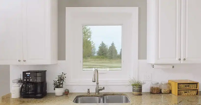 Interior view of a white Marvin Replacement Awning window above a kitchen sink.